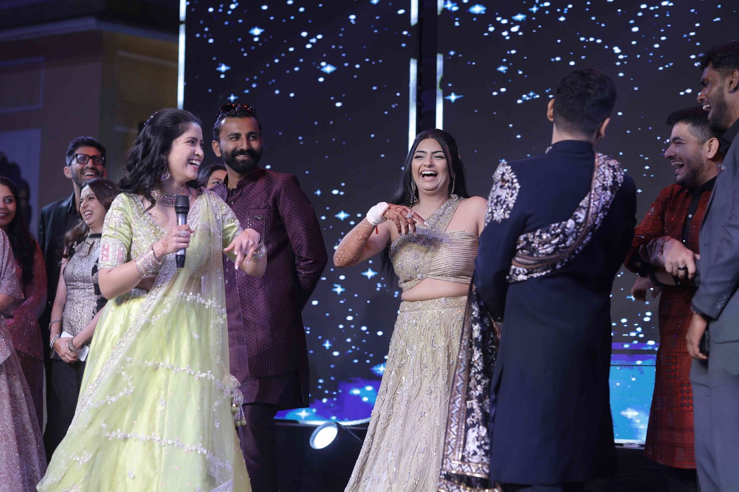 A host with a microphone leading a lively moment on the reception stage