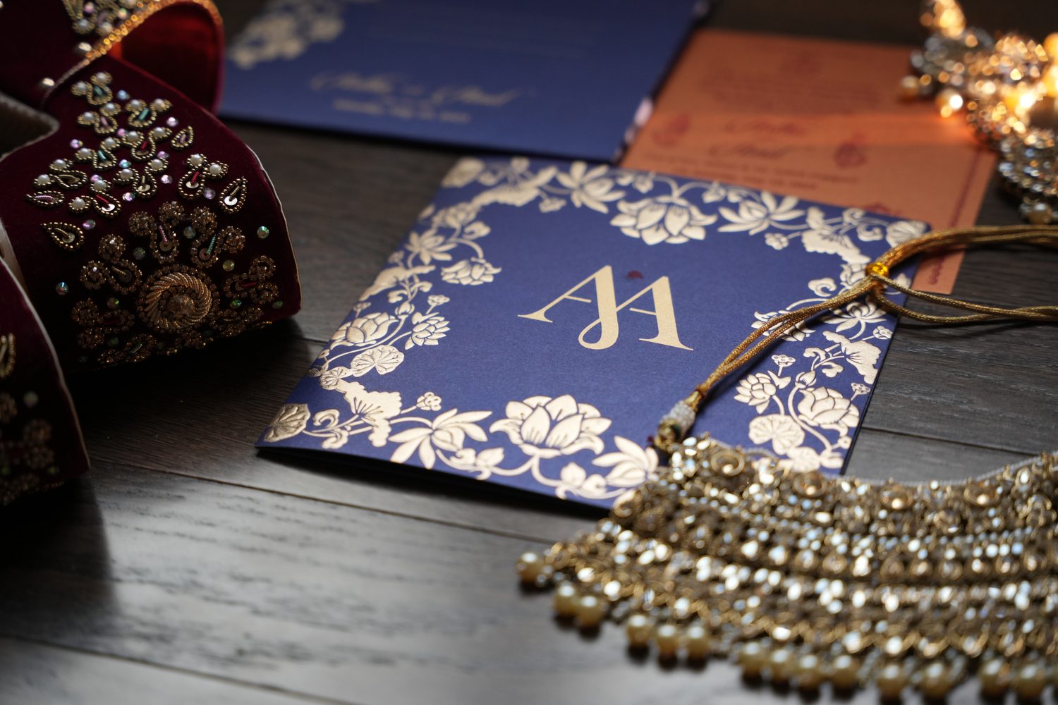 A navy and gold wedding invitation suite styled with bridal jewellery